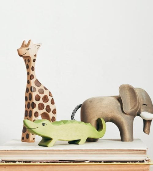 Figurine Girafe Marron Et Verte Sur Livre cottonbro studio